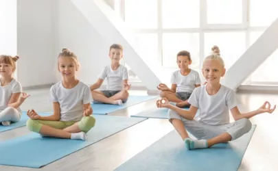 Kinder praktizieren Yoga in einem Gymnastikraum