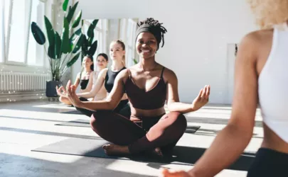 Frauen praktizieren Yoga, Beine im Schneidersitz