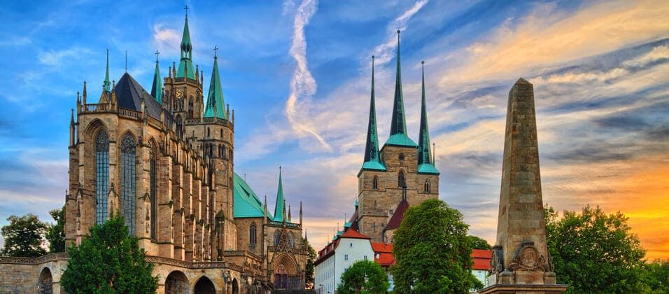 Eine Kathedrale mit Turmspitze und Obelisk im Hintergrund.