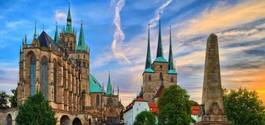 Eine Kathedrale in Erfurt mit Turmspitze und Obelisk im Hintergrund.