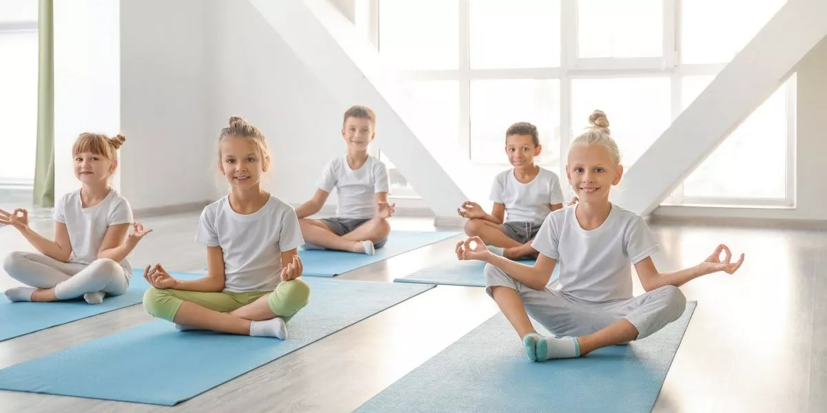 Kinder praktizieren Yoga in einem Gymnastikraum