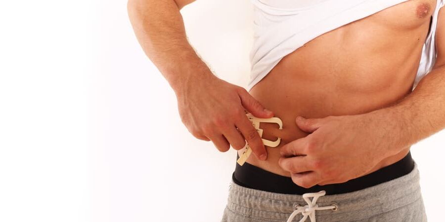 Ein Mann hält Caliper Zange an seinem Bauch.