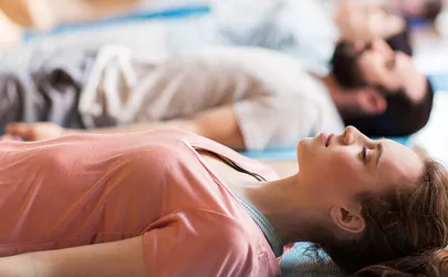 eine Gruppe von Menschen macht Meditationsübungen im Studio