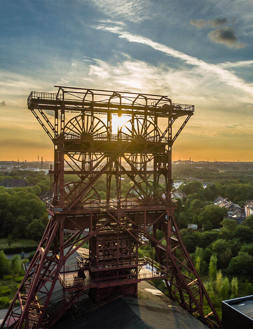Die Sonne geht über einer großen Metallkonstruktion unter.